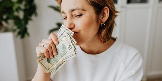 Woman Wearing Sweater Holding Dollar Bills