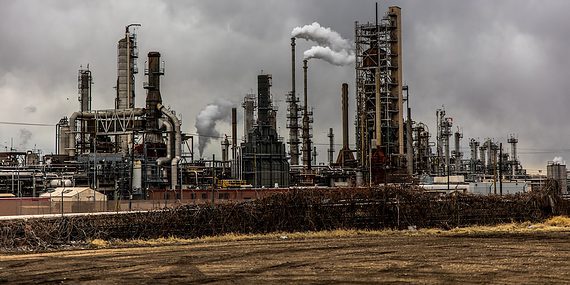 factories with smoke under cloudy sky