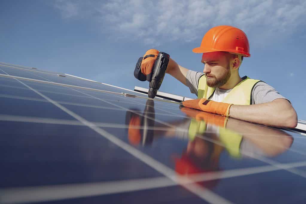 An electrician installing a solar panel