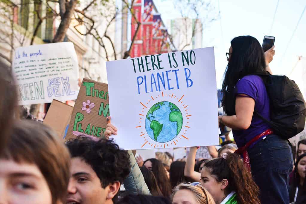 person holding there is no planet b poster