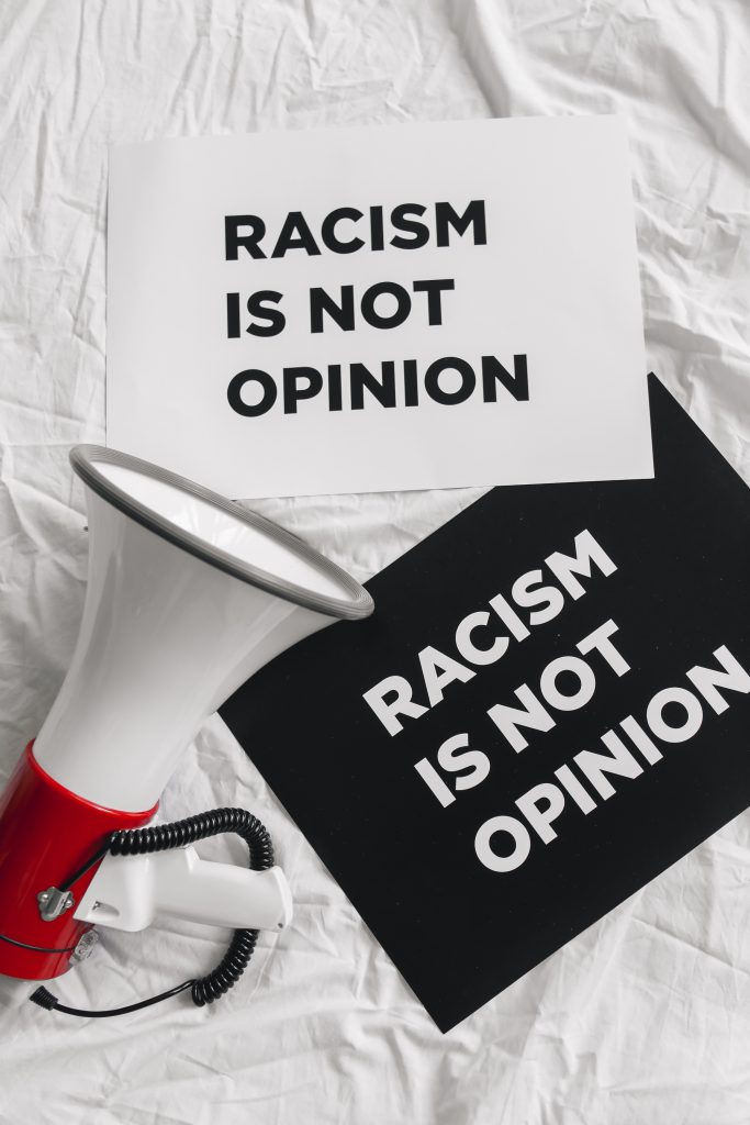 Megaphone and placards on racism on white linen
