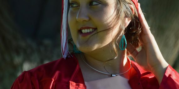 woman wearing red academic dress smiling