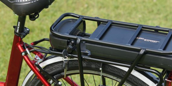 A black battery case on a red e bike in close up shot