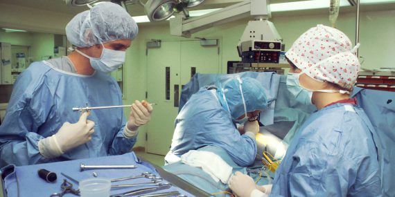 Operating Room. Two surgeons and a nurse performing a Thoracoscopy by which they are examining the pleural cavity by means of an Endoscope to later perform a biopsy.