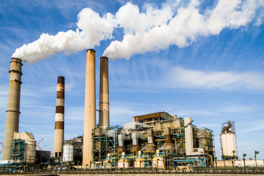 Photo of an industrial factory emitting smoke