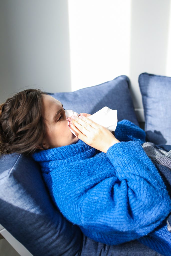 Woman in blue sweater lying on bed