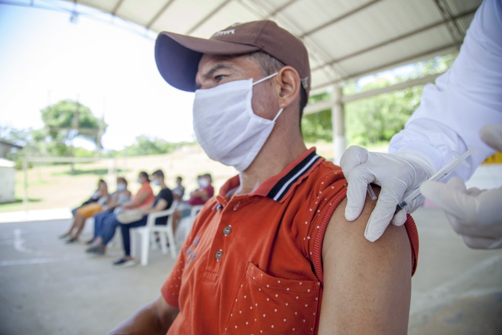 Man in red polo shirt having vaccination