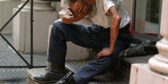 a man sitting on a step with his head in his hands
