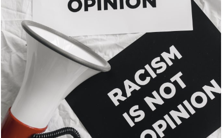 megaphone-and-placards-on-racism-on-white-linen-stockpack-pexels
