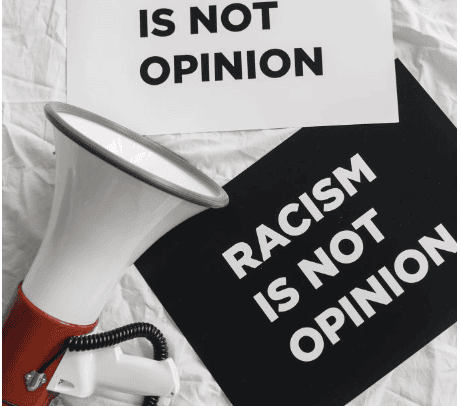 megaphone-and-placards-on-racism-on-white-linen-stockpack-pexels