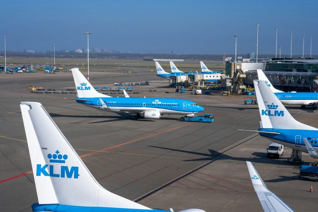 a group of blue and white jetliners sitting on top of an airport tar