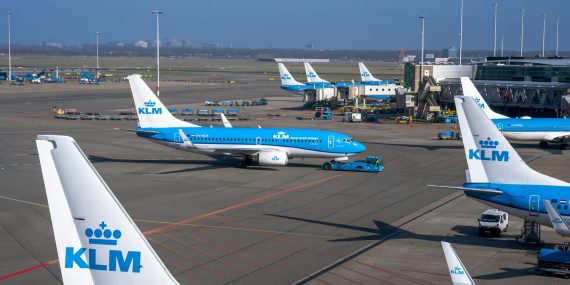 a group of blue and white jetliners sitting on top of an airport tar