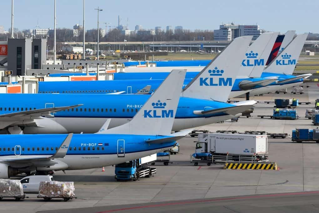 Klm airplanes parked at an airport terminal.