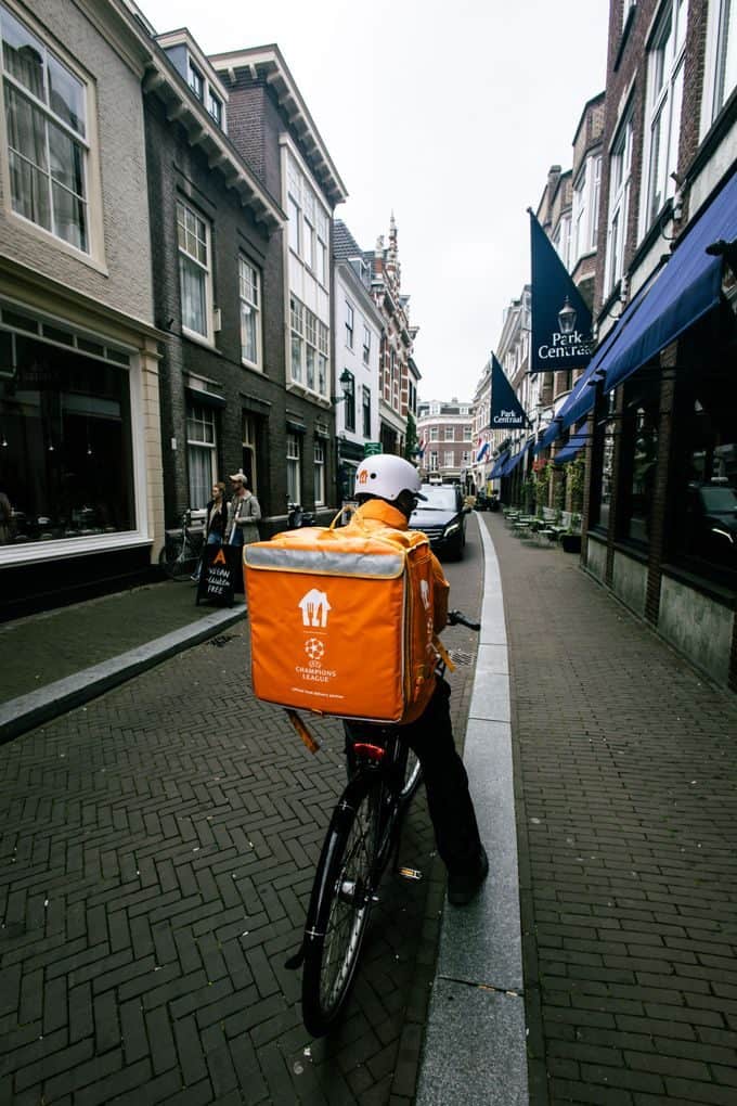 Courier on a bicycle delivering along the historic streets of Den Haag, Netherlands.