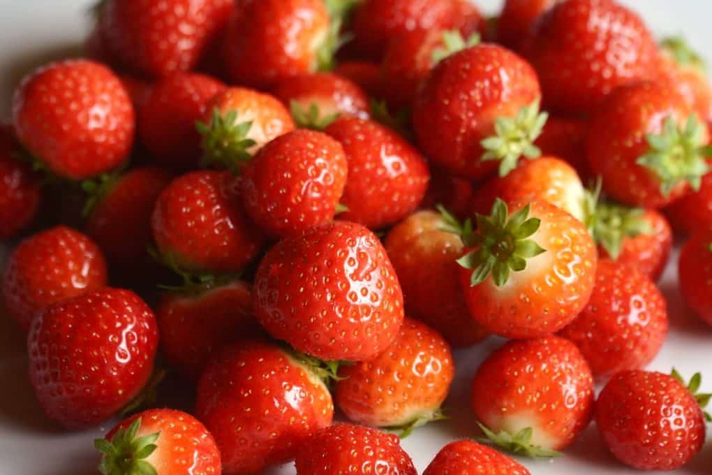 A vibrant close-up image of fresh strawberries showcasing their natural juiciness and vivid red color.